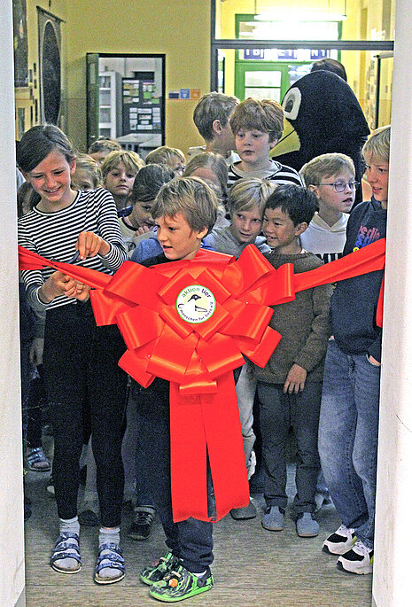 Eröffnung des Tierschutzzimmers in der Zinnowwald Grundschule in Berlin Zehlendorf Die Schüler schneiden das rote Eröffnungsband durch.