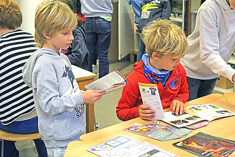 Eröffnung des Tierschutzzimmers in der Zinnowwald Grundschule in Berlin Zehlendorf Zwei Kinder stehen an einem Tisch und schauen sich Informationsmaterial an.