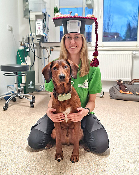 Eine Frau mit Doktorhut und ein Hund.