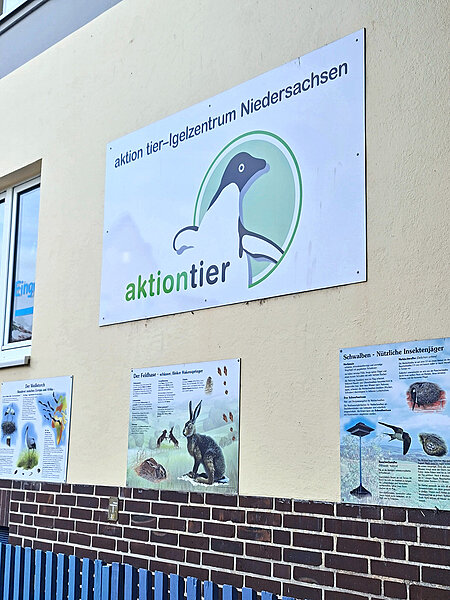 Schild mit dem Logo an einer Hauswand