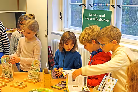 Eröffnung des Tierschutzzimmers in der Zinnowwald Grundschule in Berlin Zehlendorf Kinder unterhalten sich an einem Tisch.