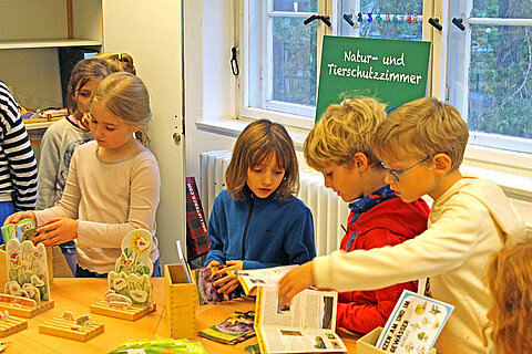 Eröffnung des Tierschutzzimmers in der Zinnowwald Grundschule in Berlin Zehlendorf Kinder unterhalten sich an einem Tisch.