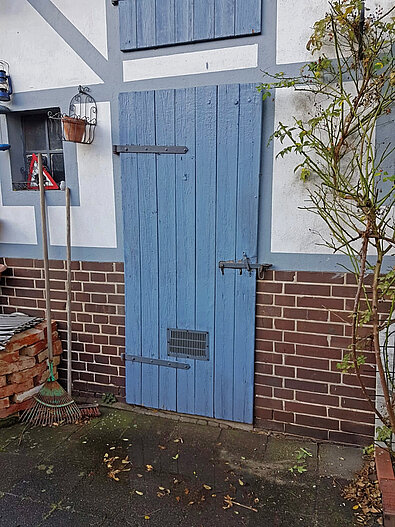 Eine blaue Tür zu einem Schuppen.