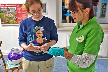 Eine Frau und eine Mitarbeiterin der Igelstation besprechen sich im Wartezimmer der Igelstation.