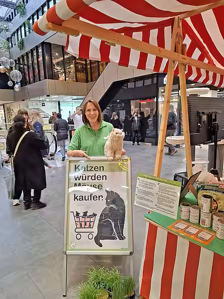 Eine Frau mit einem Aufsteller an einem Infostand