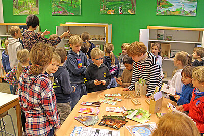 Kinder an einem Tisch mit Lernmaterialien.